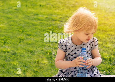 Toddler girl holding bottle of water Stock Photo