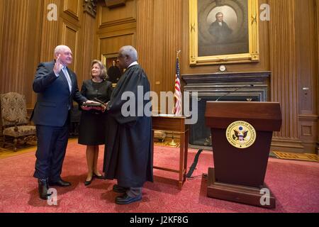 Former Georgia Gov. Sonny Perdue, left, is sworn in as the 31st U.S. Secretary of Agriculture by Supreme Court Clarence Thomas as his wife Mary Ruff looks on at the Supreme Court April 25, 2017 in Washington, DC. Stock Photo