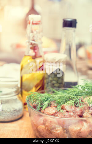 Raw pork neck meat cut in slices with marinated in glass bowl  in a modern kitchen. Shallow depth of field. Toned Stock Photo