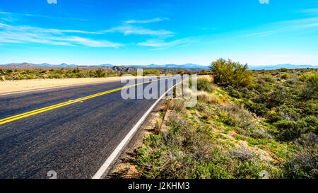 A beautiful scenic drive along the Bartlett Dam Road in the open space with green foliage and the mountains on the horizon in Tonto National Park, AZ Stock Photo