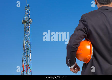 engineer holding orange helmet for workers security on contruction background Stock Photo