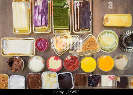 Enjoying eating cake. Top view of group of cake on the rustic wooden table Stock Photo