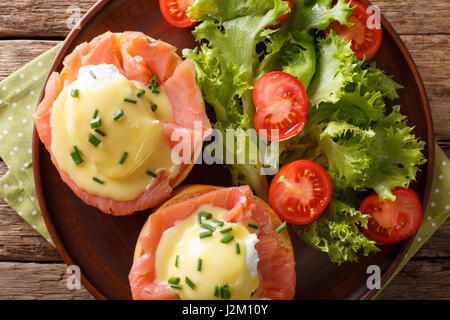 Eggs Benedict with salmon and hollandaise sauce on a plate close-up. horizontal view from above Stock Photo