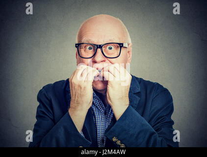 Anxious scared senior man biting fingernails Stock Photo