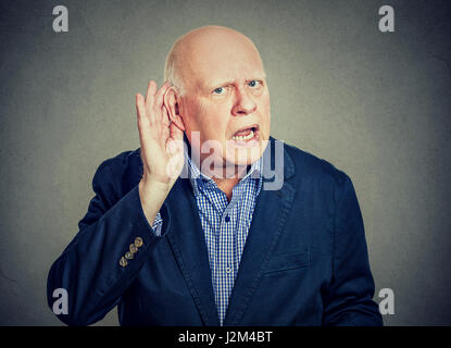 Elderly man holds his hand near ear and listening Stock Photo