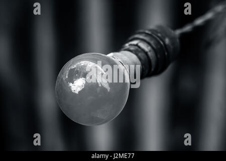 A electric old bulb tied to a holder. Stock Photo