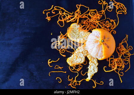 Fresh mandari zest with full fruits on a dark blue abstract background. Selective focus.