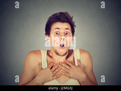 shocked surprised young man in full disbelief with hands on chest Stock Photo