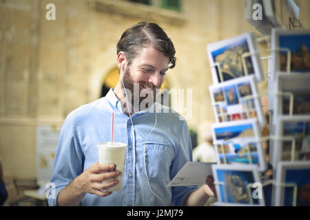 Bearded man with drink outside Stock Photo