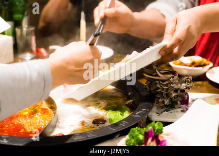 Two women are cooking the Chinese shabu hotpot Stock Photo