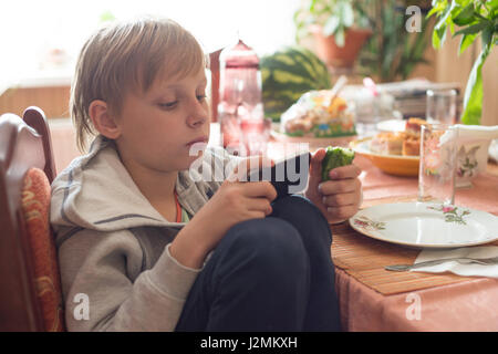 Boy uses a smartphone at home Stock Photo