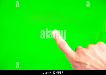 Young man types and slides on a computer screen. Digital screen with chroma key screen - green screen. Male hand. Stock Photo