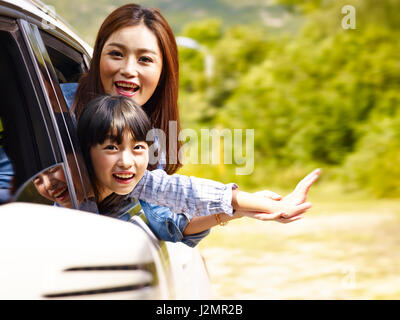 happy asian mother and daughter having fun while riding in family car. Stock Photo