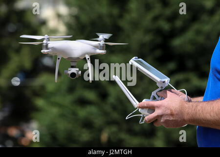 Controlling a remote helicopter drone. Drone flight remote controller in man hands Stock Photo
