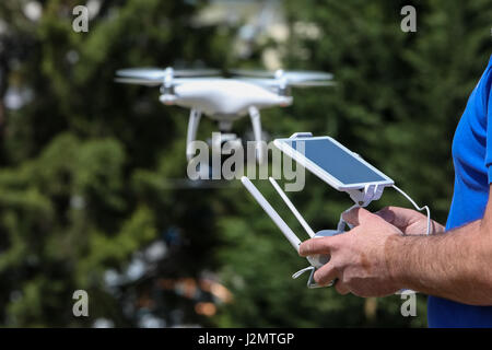 Controlling a remote helicopter drone. Drone flight remote controller in man hands Stock Photo