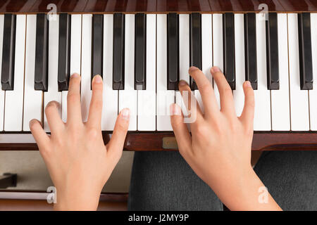 Top view close up of female's both hands playing piano Stock Photo