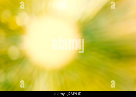 Blurred abstract background in greenish yellow tone, soft yellow circle with soft straight lines of greenish yellow light radiate outward Stock Photo