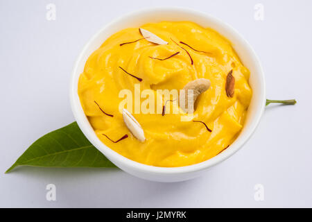 hapus or alphonso Mango pudding / Mango shrikhand or srikhand or amrakhand - Mango dessert with condensed milk magoes and nuts, selective focus over w Stock Photo