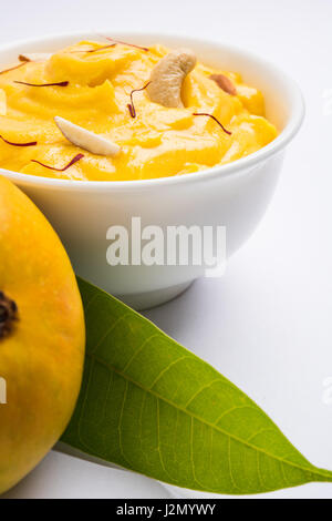 hapus or alphonso Mango pudding / Mango shrikhand or srikhand or amrakhand - Mango dessert with condensed milk magoes and nuts, selective focus over w Stock Photo