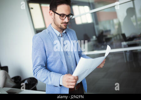 Architect holding project plans and blueprints in modern office Stock Photo
