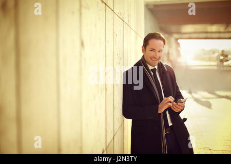 Businessman leaning on wall Stock Photo