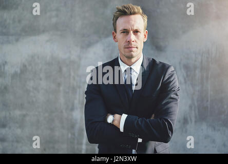 A businessman wearing stylish suit looking at camera with confidence standing with arms crossed. Stock Photo