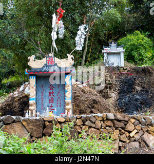 Matang, a Gejia Village in Guizhou, China.  Grave Markers in Village Cemetery, Offerings in Foreground. Stock Photo