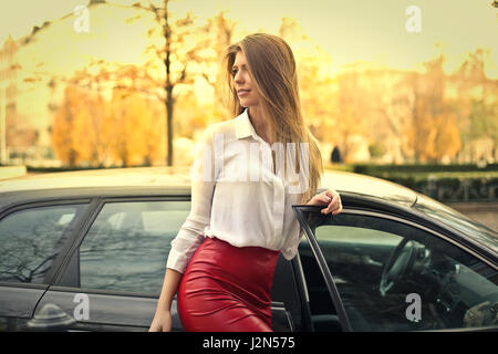 Young blonde getting out of car Stock Photo