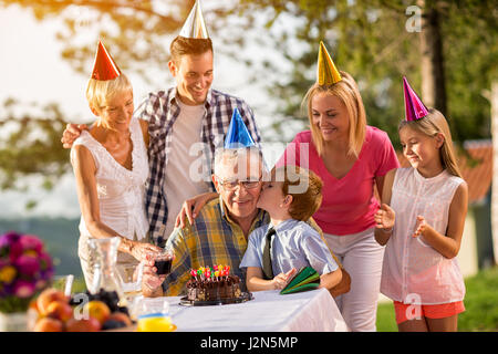 Happy family celebrating grandfathers birthday outdoors Stock Photo