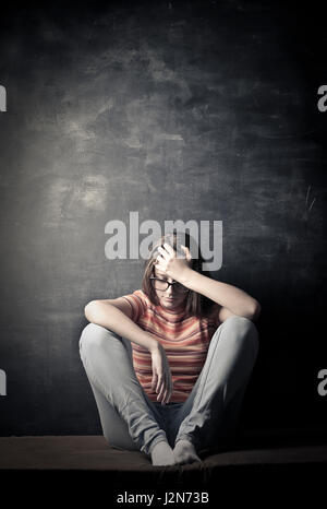 Depressed woman in front of chalkboard Stock Photo