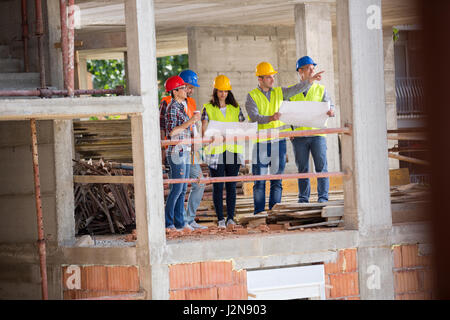 Monitoring architect group at building construction show place of building up from blue print Stock Photo