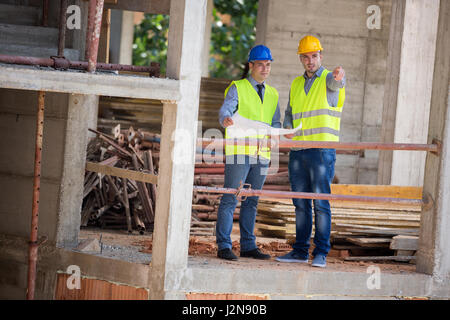Two male architects show building place and discus with colleague architect, male Stock Photo