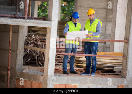 Two male architects look at blue print on open air building construction architect, male, look, Stock Photo