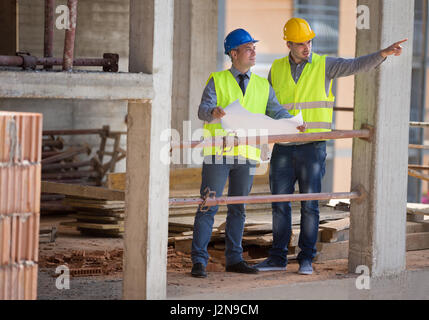 Two male architects show building place and discus with colleague architect, male Stock Photo