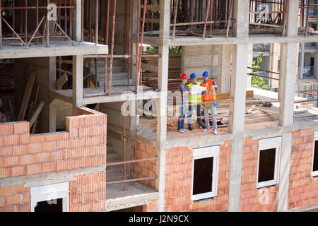Young monitoring team checking blue print on open air building construction  architects, young, team, Stock Photo