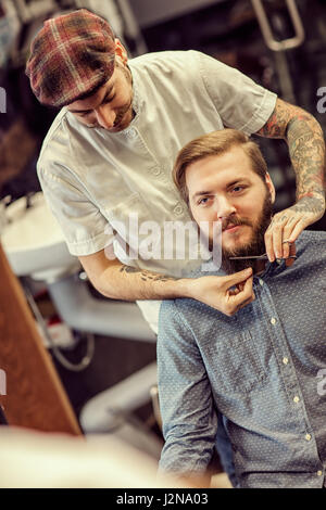 male hairdresser cutting beard hipster customer