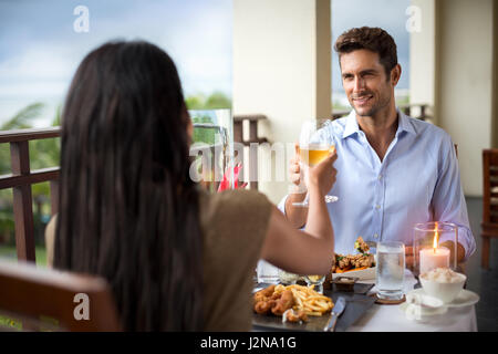 romantic young couple at table toasting, dinner on the balcony Stock Photo