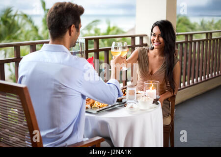 Happy couple toasting during romantic dinner on the balcony Stock Photo