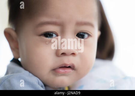 Asian 5 months baby boy crying in mother arm. Stock Photo