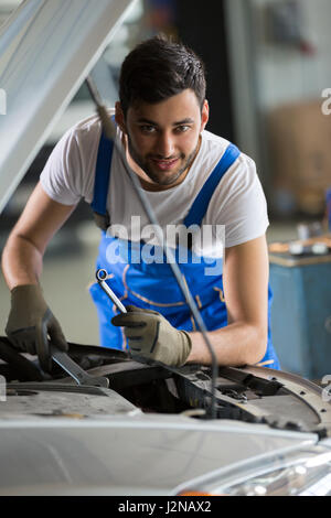 Mechanic working on an engine in a garage Stock Photo - Alamy