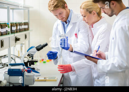 Young laboratory team worker works with microscope Stock Photo