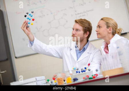 Chemists in classroom show molecular model and studying with his assistant Stock Photo