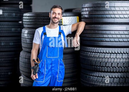 mechanic with car tires in tire store Stock Photo