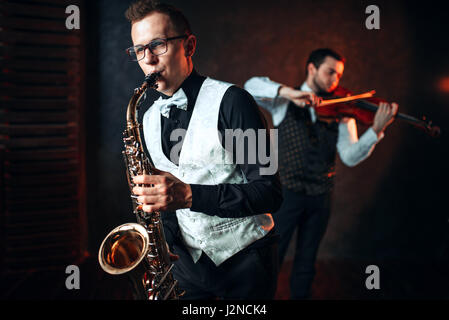 Sax man and fiddler duet playing classical melody. Jazz man and violinist Stock Photo