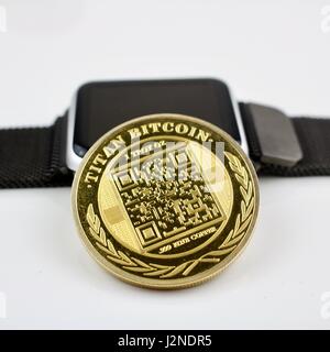 Cryptocurrency physical gold titan bitcoin and black smartwatch. Stock Photo