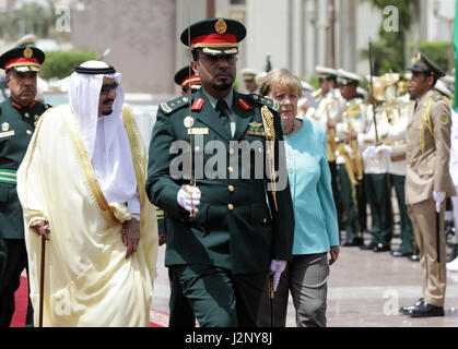 dpatop - German Chancellor Angela Merkel (m,CDU) is greeted with military honors by the King of  Saudi Arabia, Salman bin Abdulaziz Al Saud (l) in Jeddah, Saudi Arabia, 30 April 2017. Photo: Kay Nietfeld/dpa Stock Photo