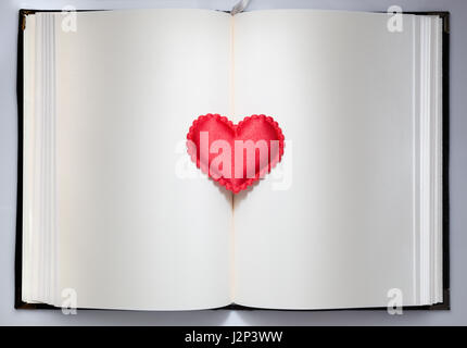 Big red heart and small red hearts on open book with empty pages, space for text, clean and elegant design Stock Photo