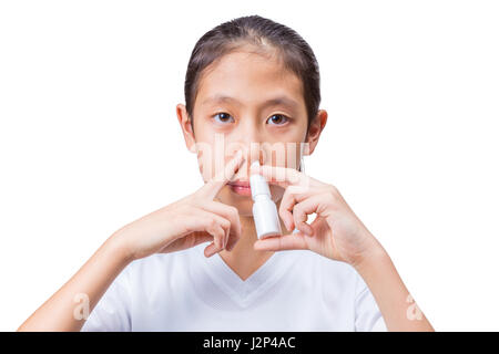 Teenage asian girl using nasal spray with one hand holding the spray bottle to her nose's left side and an index finger from the other hand pressing o Stock Photo