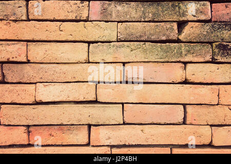 straight on view of terracotta brick wall in vintage retro color style, good for using as background Stock Photo