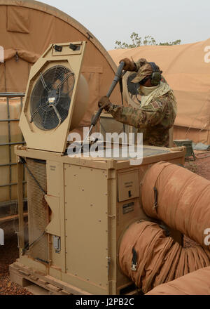 Staff Sgt. Julian Johnson, 768th Expeditionary Air Base Squadron NCO in charge of Heating Ventilation and Air Conditioning, cleans an HVAC unit at Nigerien Air Base 101, Niger, April 3, 2017. While cleaning the units, HVAC members spray the inside and outside of units, pull out and clean the air filters, and perform a systems check once finished. (U.S. Air Force photo by Senior Airman Jimmie D. Pike) Stock Photo